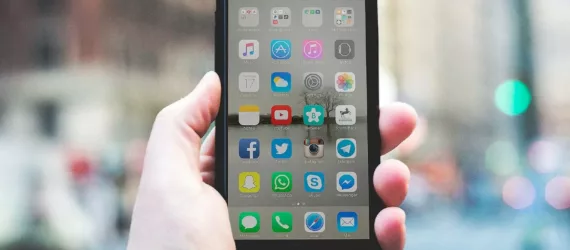 person holding a space gray iPhone 6 and black case